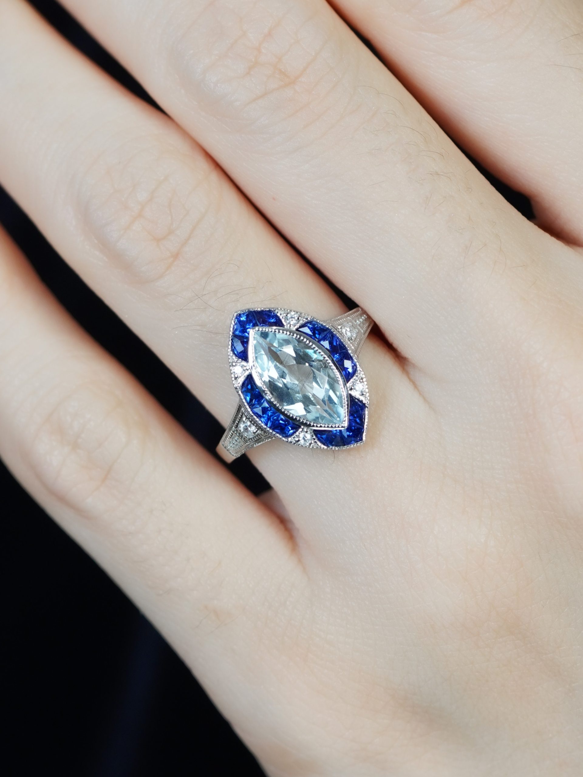 marquise-aquamarine-and-sapphire-engagement-ring-on-body-front-near Marquise Aquamarine Sapphire and Diamond Engagement Ring on Body Near