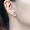 Round Diamond and Ruby Stud Earrings on Body Front Distant round diamond ruby stud earrings 14k gold front distant